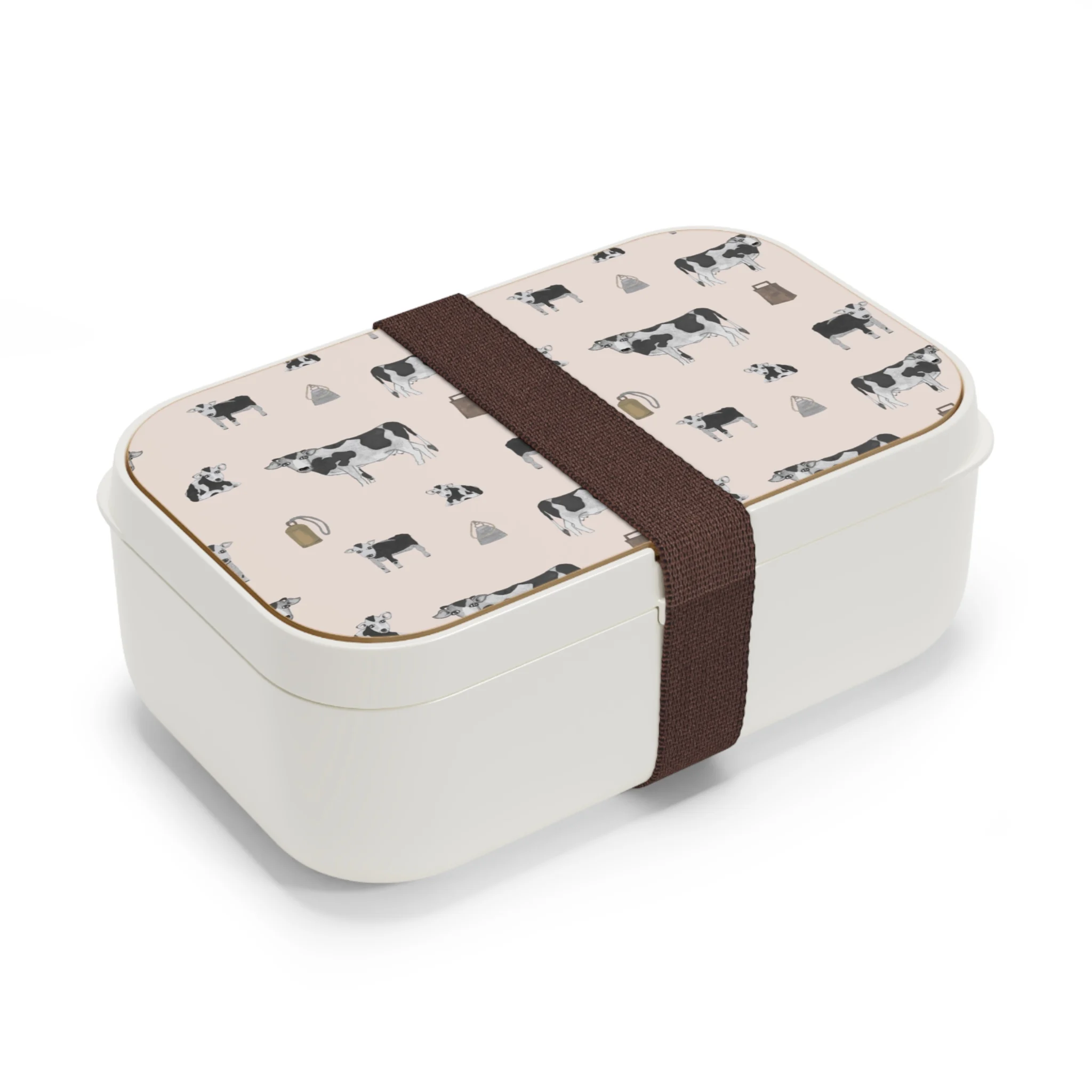 Whimsical hand-drawn black and white cows in black, white, and grey on a pale pink background, featured on a practical bento lunchbox with a natural wood lid. The design combines charm and functionality for on-the-go meals.