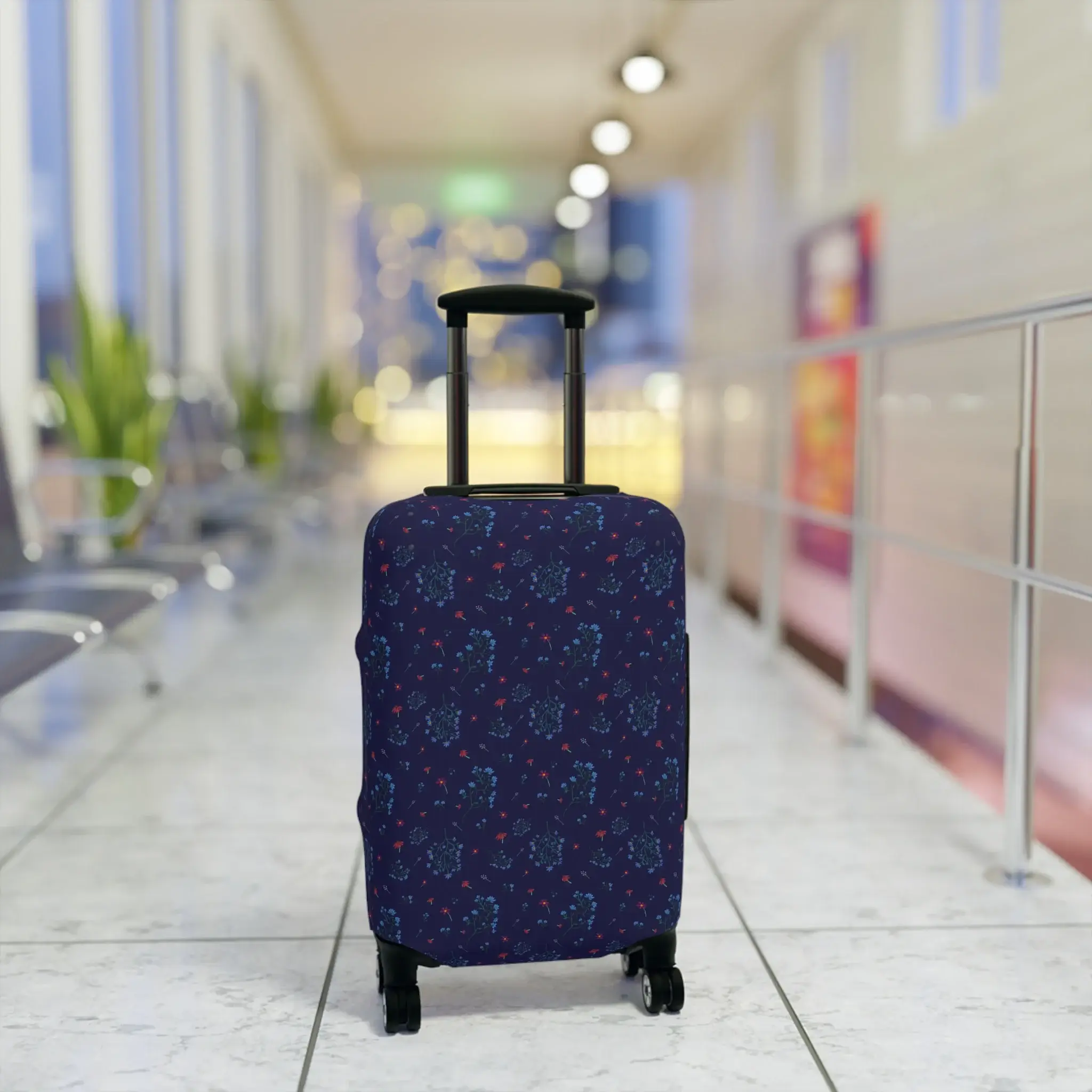 Close-up of a navy blue floral luggage cover from the Woodland Bloom collection, snugly fitted on a suitcase.