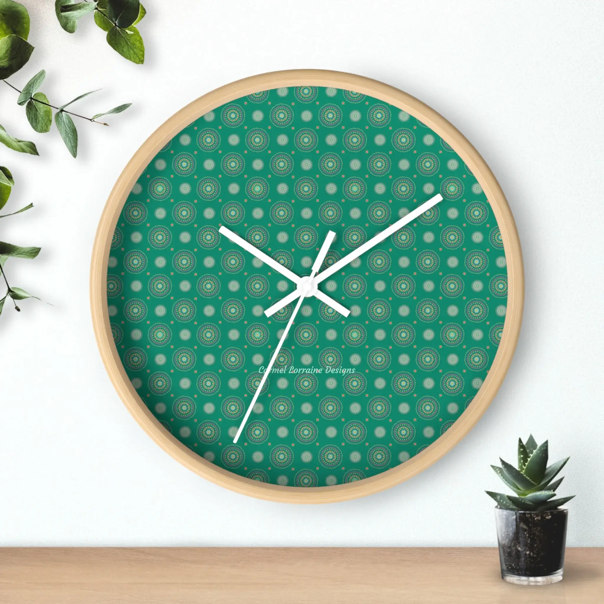 Floral mandala wall clock with white hands, no numbers, and a light wood base featuring a jade green background.